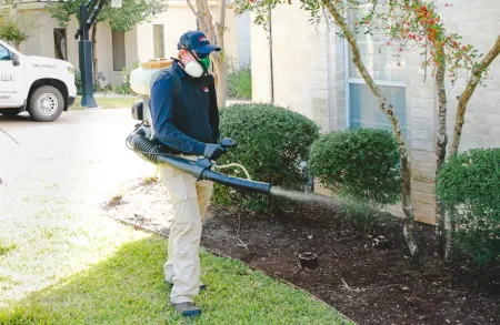 Tech spraying perimeter of home for mosquitoes